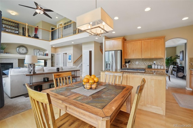 9158 Forest St, Firestone, CO 80504 - dining area with light wood-type flooring, a ceiling fan, arched walkways, recessed lighting, and stairs