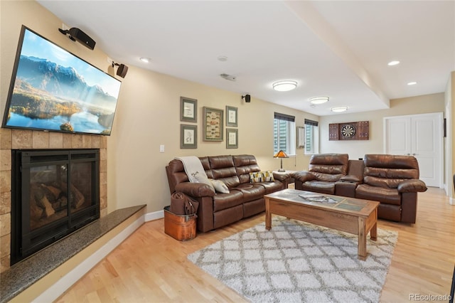 9158 Forest St, Firestone, CO 80504 - living room with wood finished floors, a tiled fireplace, recessed lighting, and baseboards