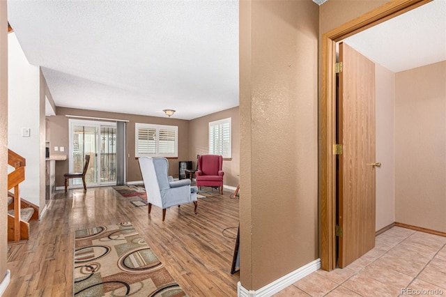 corridor with light wood-type flooring and baseboards