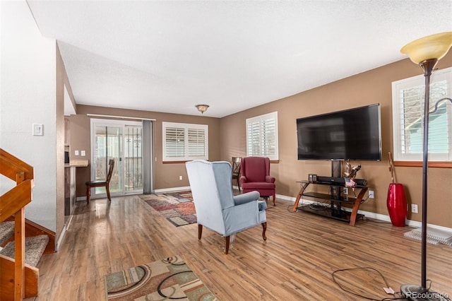 living room featuring baseboards, plenty of natural light, and wood finished floors