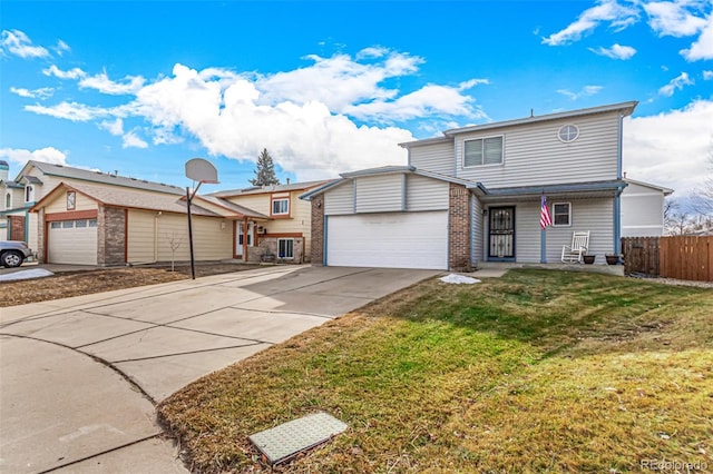 traditional home with driveway, fence, a front yard, a garage, and brick siding