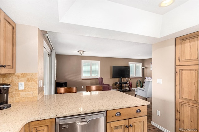 kitchen featuring baseboards, light stone countertops, open floor plan, a peninsula, and stainless steel dishwasher