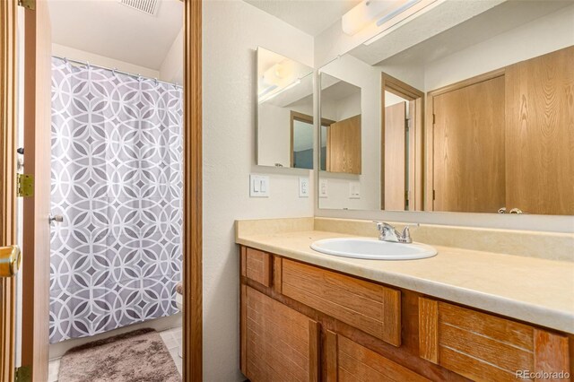 full bath featuring visible vents, vanity, and a shower with shower curtain