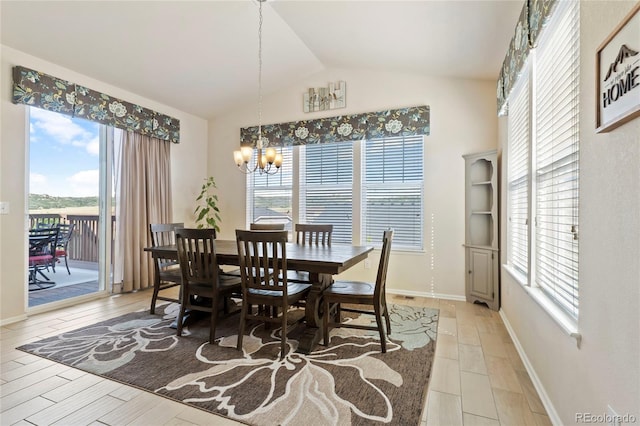 dining area featuring a wealth of natural light, light wood-type flooring, an inviting chandelier, and vaulted ceiling