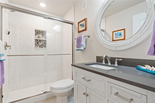 full bath with visible vents, a stall shower, toilet, and vanity