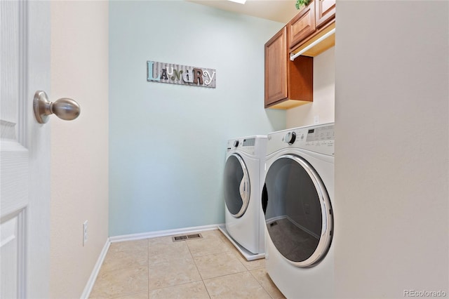 laundry area with visible vents, cabinet space, light tile patterned flooring, baseboards, and washing machine and clothes dryer