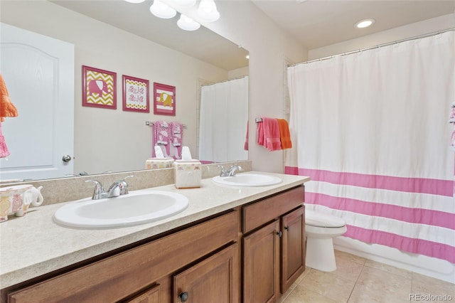 bathroom featuring tile patterned floors, toilet, double vanity, and a sink