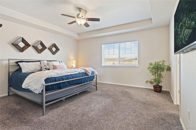 bedroom with baseboards, a raised ceiling, carpet, and ceiling fan