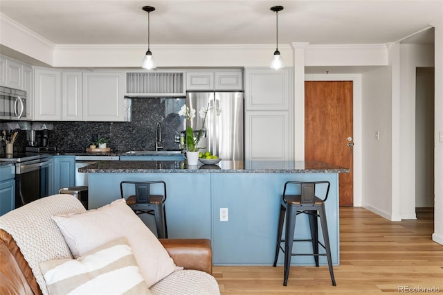 601 W 11th Ave Unit 910, Denver, CO 80204 - kitchen with stainless steel appliances, a sink, a kitchen breakfast bar, backsplash, and crown molding