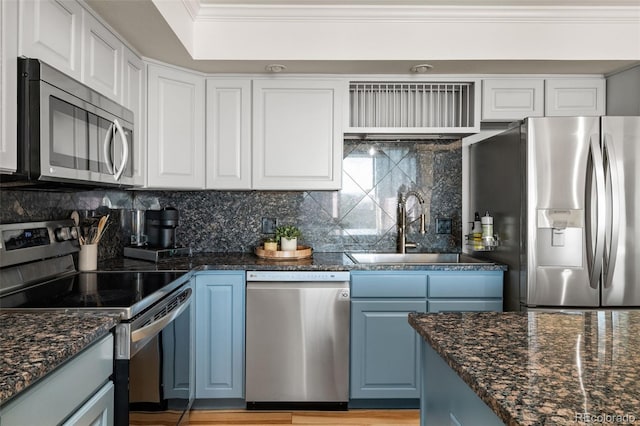 601 W 11th Ave Unit 910, Denver, CO 80204 - kitchen featuring appliances with stainless steel finishes, a sink, blue cabinets, decorative backsplash, and crown molding
