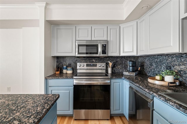 601 W 11th Ave Unit 910, Denver, CO 80204 - kitchen with stainless steel appliances, crown molding, blue cabinetry, backsplash, and white cabinets