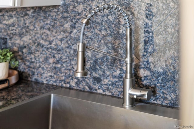 601 W 11th Ave Unit 910, Denver, CO 80204 - kitchen view of a sink, dark countertops, backsplash, and white cabinets
