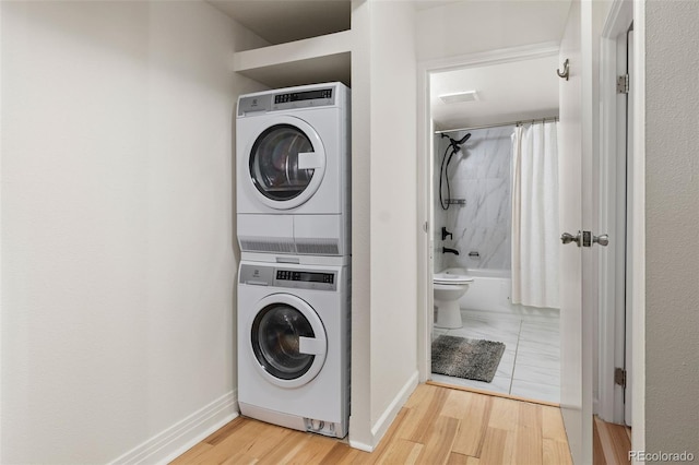 601 W 11th Ave Unit 910, Denver, CO 80204 - washroom featuring stacked washing machine and dryer, wood finished floors, and baseboards