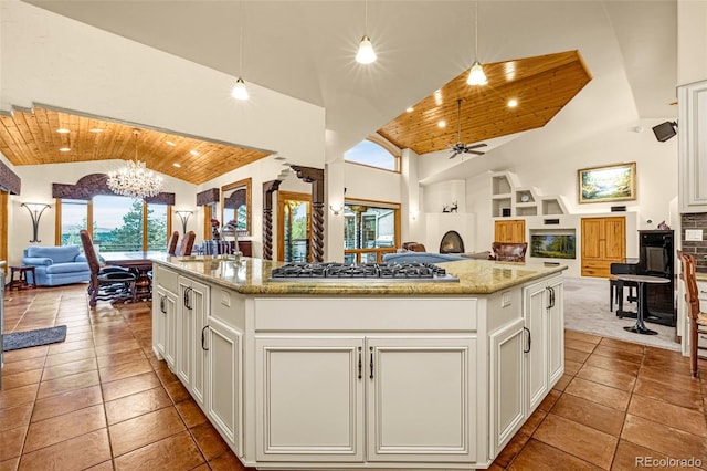 17995 Minglewood Trl, Monument, CO 80132 - kitchen featuring open floor plan, wooden ceiling, stainless steel gas cooktop, healthy amount of natural light, and high vaulted ceiling