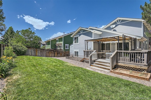 rear view of house featuring a yard and a deck