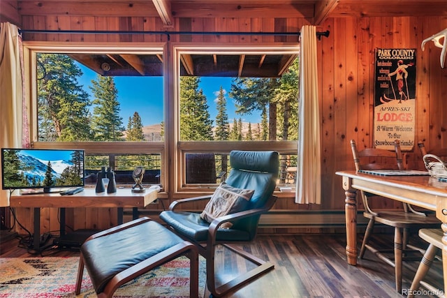 sitting room with wood walls, hardwood / wood-style floors, and beamed ceiling