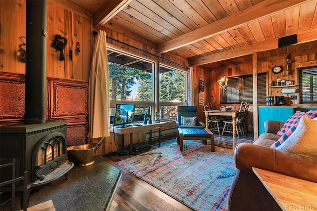 interior space featuring wood ceiling, a wood stove, and beamed ceiling