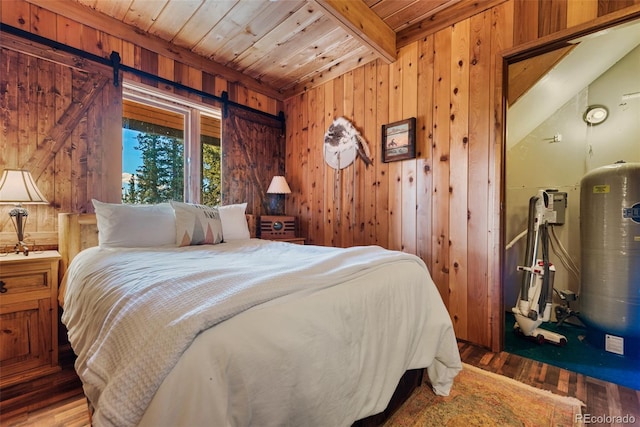 bedroom featuring wooden ceiling, wood-type flooring, wood walls, a barn door, and beam ceiling