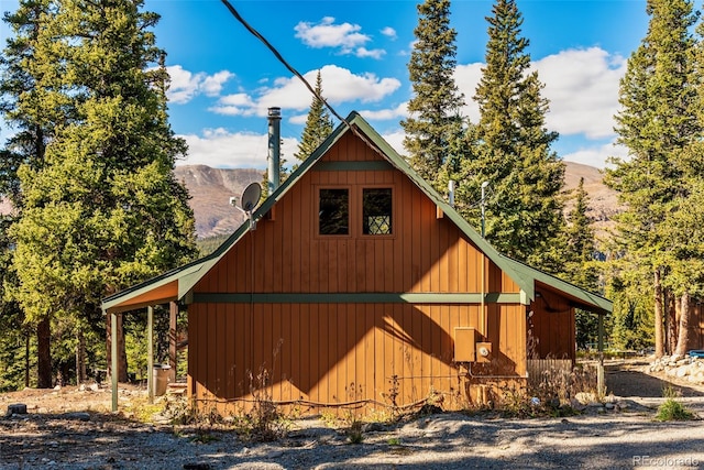 view of property exterior with an outdoor structure and a mountain view