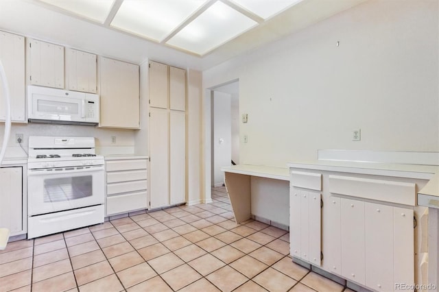 11815 E Louisiana Ave, Aurora, CO 80012 - kitchen with white appliances, light countertops, light tile patterned floors, and white cabinetry