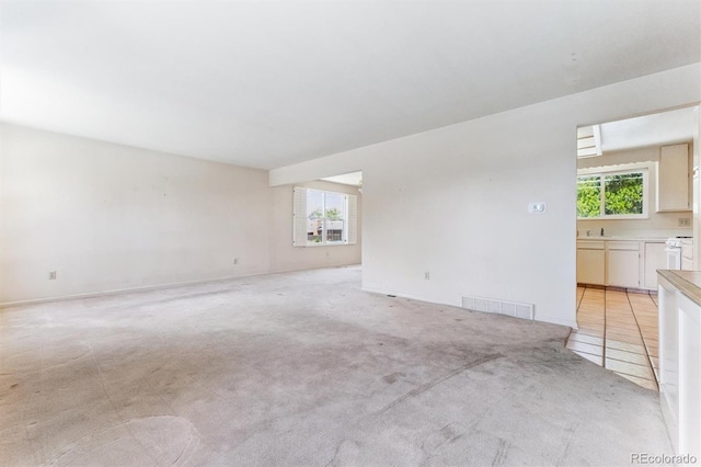 11815 E Louisiana Ave, Aurora, CO 80012 - unfurnished living room featuring plenty of natural light and light colored carpet