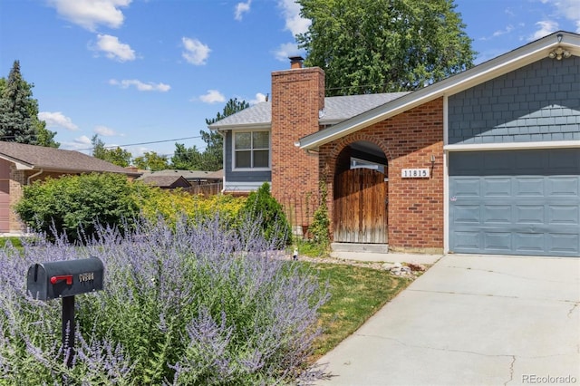 11815 E Louisiana Ave, Aurora, CO 80012 - ranch-style home with brick siding, an attached garage, a chimney, and driveway