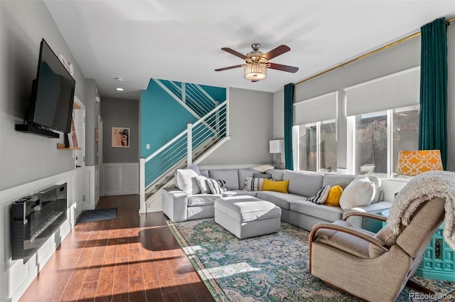 living room featuring ceiling fan, a fireplace, and dark hardwood / wood-style flooring