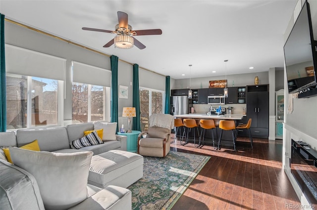 living room with dark hardwood / wood-style floors and ceiling fan