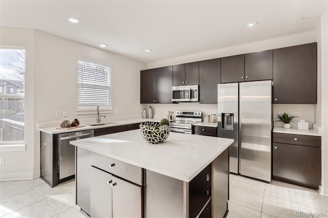 kitchen with light tile patterned floors, recessed lighting, a sink, appliances with stainless steel finishes, and a center island