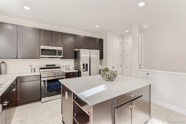 kitchen featuring appliances with stainless steel finishes, light tile patterned flooring, a kitchen island, and dark brown cabinetry