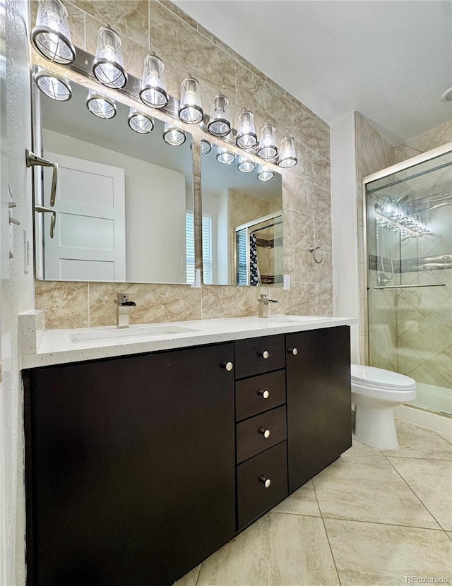 full bath featuring tile walls, double vanity, decorative backsplash, a stall shower, and a sink