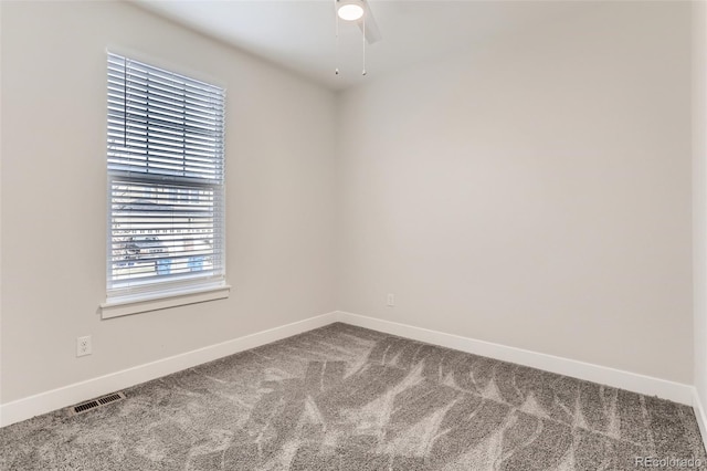 carpeted empty room with visible vents, ceiling fan, and baseboards