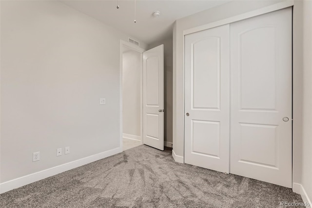 unfurnished bedroom with baseboards, a closet, visible vents, and light colored carpet