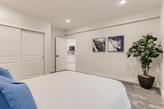 carpeted bedroom with recessed lighting, a sink, visible vents, baseboards, and a closet