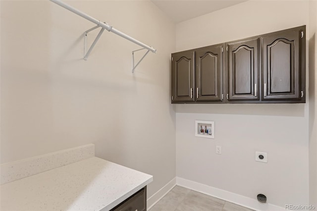 clothes washing area with cabinet space, baseboards, washer hookup, and hookup for an electric dryer