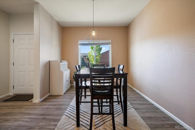 dining area with baseboards and wood finished floors
