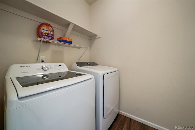 washroom with independent washer and dryer, dark wood-style flooring, and baseboards