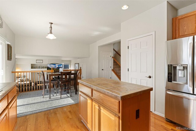 12978 Newport Way, Thornton, CO 80602 - kitchen featuring stainless steel refrigerator with ice dispenser, tile counters, light wood-style flooring, recessed lighting, and pendant lighting