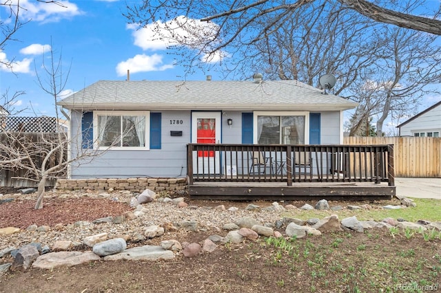 view of front of home with a shingled roof and fence