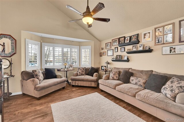 living room with dark wood-type flooring, high vaulted ceiling, baseboards, and a ceiling fan