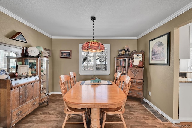 dining area featuring a textured ceiling, crown molding, dark wood finished floors, and baseboards