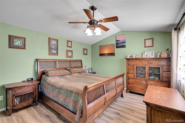 bedroom featuring baseboards, vaulted ceiling, and light wood finished floors