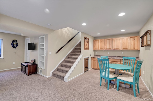 kitchen with recessed lighting, beverage cooler, light colored carpet, light countertops, and light brown cabinetry