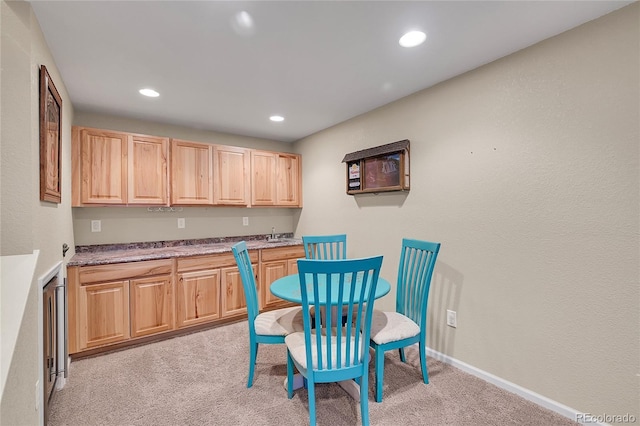 kitchen with recessed lighting, light brown cabinets, baseboards, and light colored carpet