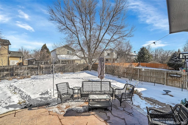 snow covered patio with a fenced backyard