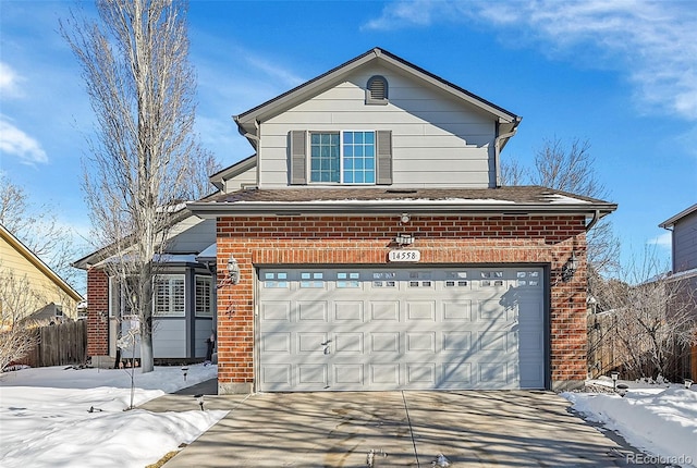 traditional-style house with brick siding, fence, driveway, and a garage