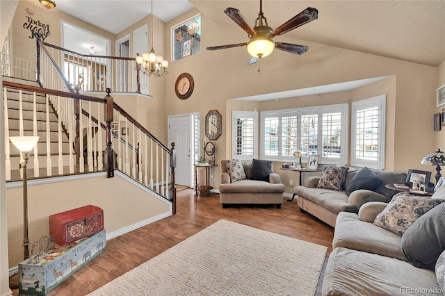 14558 Vine St, Thornton, CO 80602 - living room featuring a chandelier, stairs, ceiling fan, wood finished floors, and high vaulted ceiling