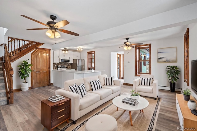 living room with ceiling fan and light wood-type flooring