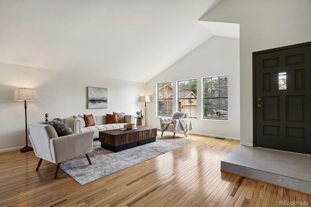 living room featuring high vaulted ceiling, baseboards, and hardwood / wood-style flooring