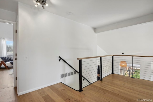staircase featuring baseboards, visible vents, and wood finished floors